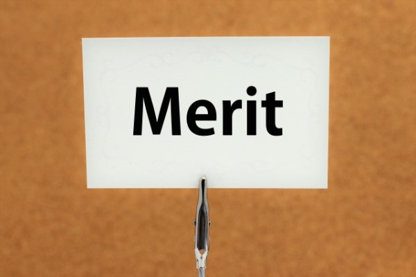 「Merit」と書かれた紙がコルクボードに固定されている画像