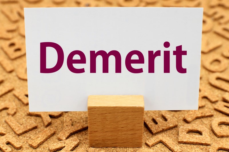 「Demerit」と書かれた紙が木片で固定されている画像